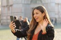 Portrait of brazilian woman making a video call using smart phone in city street Royalty Free Stock Photo