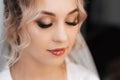 portrait of a bride in a beauty salon, beautiful blonde with hair and makeup in a veil.