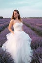 Portrait of the bride in a lavender field of flowers dressed in a white dress. Girl in the lavender bushes in summer Royalty Free Stock Photo