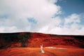 Portrait of a bride model in a golden wedding evening dress, in a yellow-red sandy quarry, in the crater of a volcano in