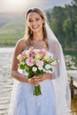 Portrait, bride and smile with flower bouquet at lake, nature and celebration of commitment, love and marriage. Happy