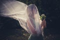 Portrait of bride with veil and bouquet of wild flowers outdoor