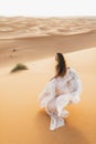 Portrait of bride woman in amazing wedding dress in Sahara desert dunes, Morocco Royalty Free Stock Photo