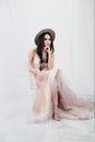 Portrait of bride. A young attractive brunette woman with long black hair in braids. White wedding dress and beige hat Royalty Free Stock Photo