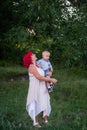 Portrait of bright diversity, extraordinary mother little son embrace in forest. Woman has pink hair Royalty Free Stock Photo