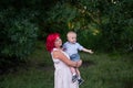 Portrait of bright diversity, extraordinary mother little son embrace in forest. Woman has pink hair Royalty Free Stock Photo