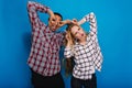 Portrait brightful happy moments of funny couple fooling around on blue background. Having fun, weekends, relaxing Royalty Free Stock Photo