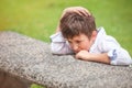 Brooding boy in the park outdoors