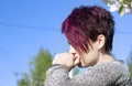 Portrait of a brooding girl with short-cropped pink hair