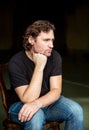 Portrait of brooding man, sitting on chair