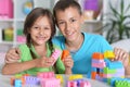 Portrait of brother and sister playing with colorful plastic blocks Royalty Free Stock Photo