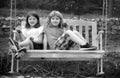 Portrait of brother and sister swinging on swing in summer park outdoors. Little boy and girl kids enjoying summer at Royalty Free Stock Photo