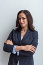 Portrait of a brunette business woman in a blue jacket with a malicious smile