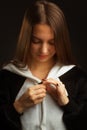 Portrait of a brunette girl in the Studio on a plain black background in black and white pajamas with a hood Royalty Free Stock Photo