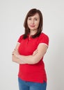 Portrait of brunette serious woman in blank white t-shirt. Crossed arms on chest. Copy space on white background.Mother day Royalty Free Stock Photo