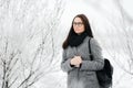 Portrait of a brunette wearing glasses and a gray coat