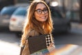 Portrait of brunette woman carrying laptop while walking through city street Royalty Free Stock Photo