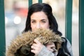 Portrait of brunette woman hugging her own coat to wrap herself up Royalty Free Stock Photo