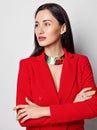 Portrait of brunette woman with permanent makeup in red jacket with deep neckline on naked body standing looking aside Royalty Free Stock Photo