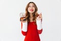 Portrait of brunette woman 20s wearing Santa Claus red costume smiling and holding Christmas snow ball, isolated over white Royalty Free Stock Photo