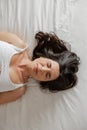 Portrait of brunette woman sleeping, lying in cozy bed with eyes closed Royalty Free Stock Photo