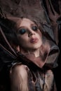 Portrait of a brunette woman through a transparent dark fabric. Beauty and makeup girl. There is no focus