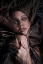 Portrait of a brunette woman through a transparent dark fabric. Beauty and makeup girl. There is no focus