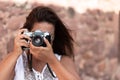 Portrait of a brunette young woman taking a picture with a vintage camera Royalty Free Stock Photo