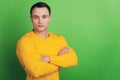 Portrait of brutal handsome confident guy crossed arms on green background Royalty Free Stock Photo