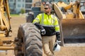 Portrait of builder in a construction site. Builder with excavator ready to build new house. Construction builder wear