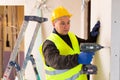 Portrait of builder handyman working with electric drill in repairable room Royalty Free Stock Photo