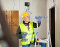 Portrait of builder handyman working with electric drill in repairable room Royalty Free Stock Photo