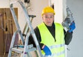 Portrait of builder handyman working with electric drill in repairable room Royalty Free Stock Photo