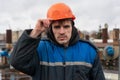 Portrait of a builder in a helmet and working dirty uniform. holds a hard hat.