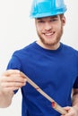 Portrait, builder and man with a hard hat, measurement tape and smile isolated on a white studio background. Face