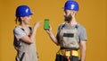 Portrait of building contractors pointing at smartphone Royalty Free Stock Photo