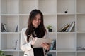 Portrait of business asian woman happy smile holding check list on clipboard and pen at modern offlice Royalty Free Stock Photo