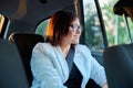 Portrait of business elegant middle-aged woman in car in back passenger seat Royalty Free Stock Photo