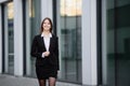 Portrait of a business lady. A happy businesswoman walks near an office building