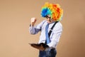 Portrait of business man in clown wig using a tablet to access t Royalty Free Stock Photo