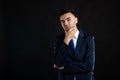 Portrait of business man wearing blue business suit and tie making thinking gesture hand under chin Royalty Free Stock Photo