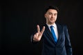 Portrait of business man wearing blue business suit and tie showing peace gesture Royalty Free Stock Photo