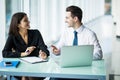 Portrait of business partner sitting at his tidy glass desk in front of his computer in a luminous white office. Royalty Free Stock Photo