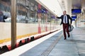 Portrait of business people running to catch the train in station Royalty Free Stock Photo