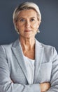 Portrait, business and senior woman arms crossed, leadership and opportunity against studio background. Face, mature