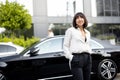 Portrait of business woman in front of a luxury car outdoors