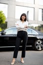 Portrait of business woman in front of a luxury car outdoors