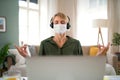 Portrait of business woman indoors in office doing yoga at desk, mental health and coronavirus concept. Royalty Free Stock Photo