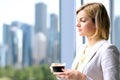 Portrait of business woman standing with coffee near window. Downtown area background. Royalty Free Stock Photo