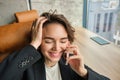 Portrait of business woman in suit, sitting in her office and answering a phone call with pleased smile, having a Royalty Free Stock Photo